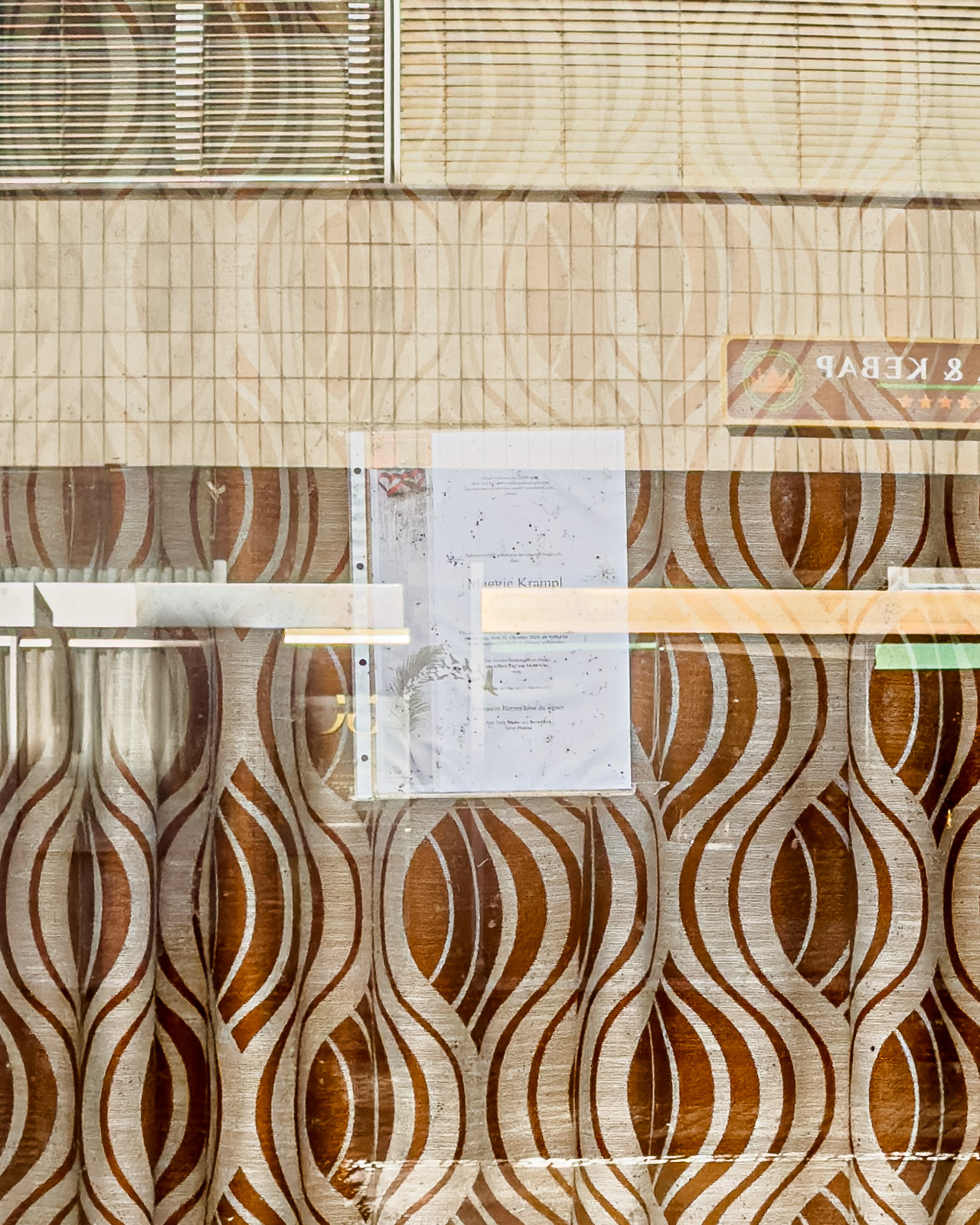 Shop window with patterned curtains on Zeltweg’s former main street (Hauptstraße), Austria.