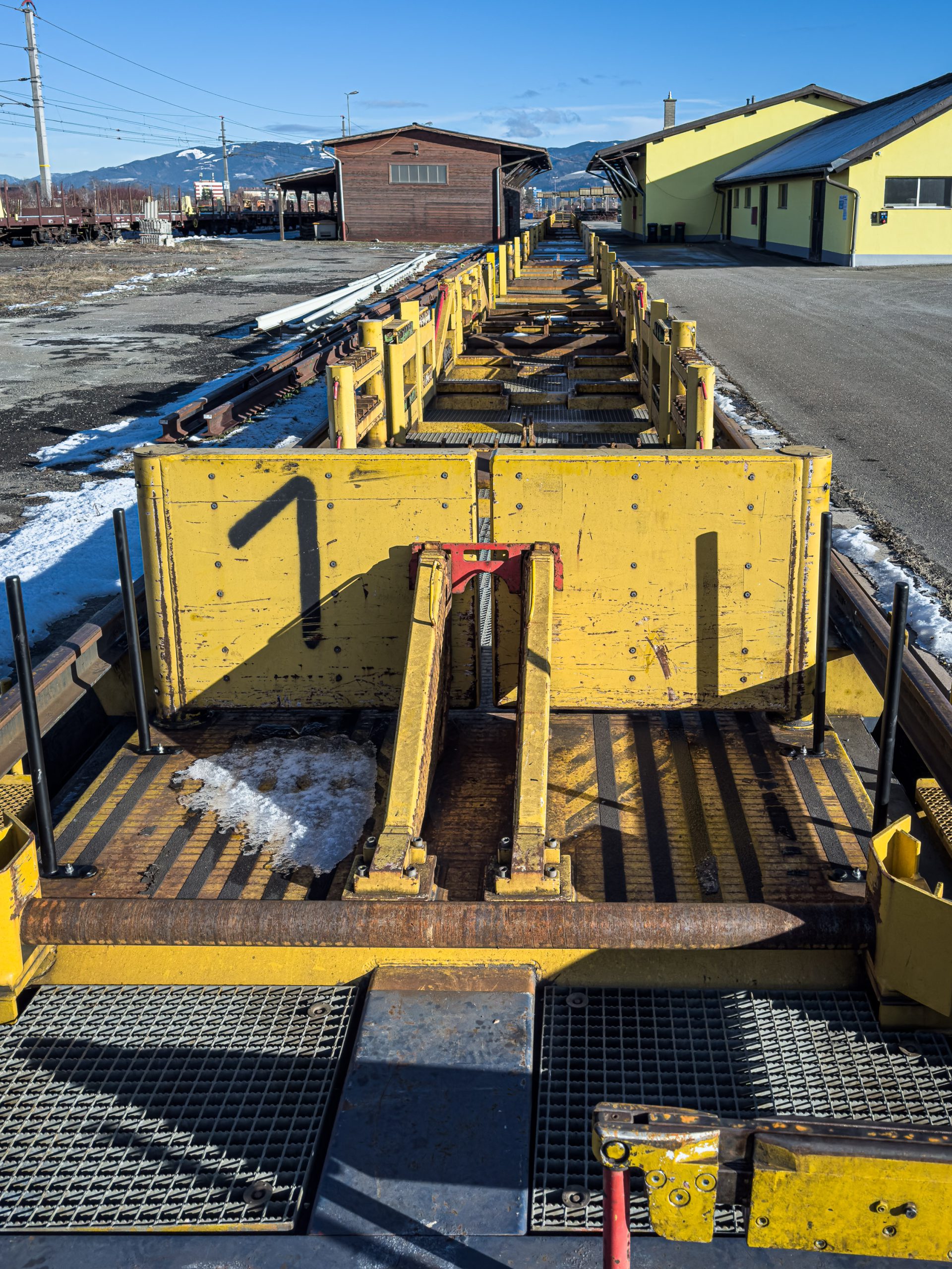 Rail loading platform and industrial equipment at an active site in Zeltweg, Austria.