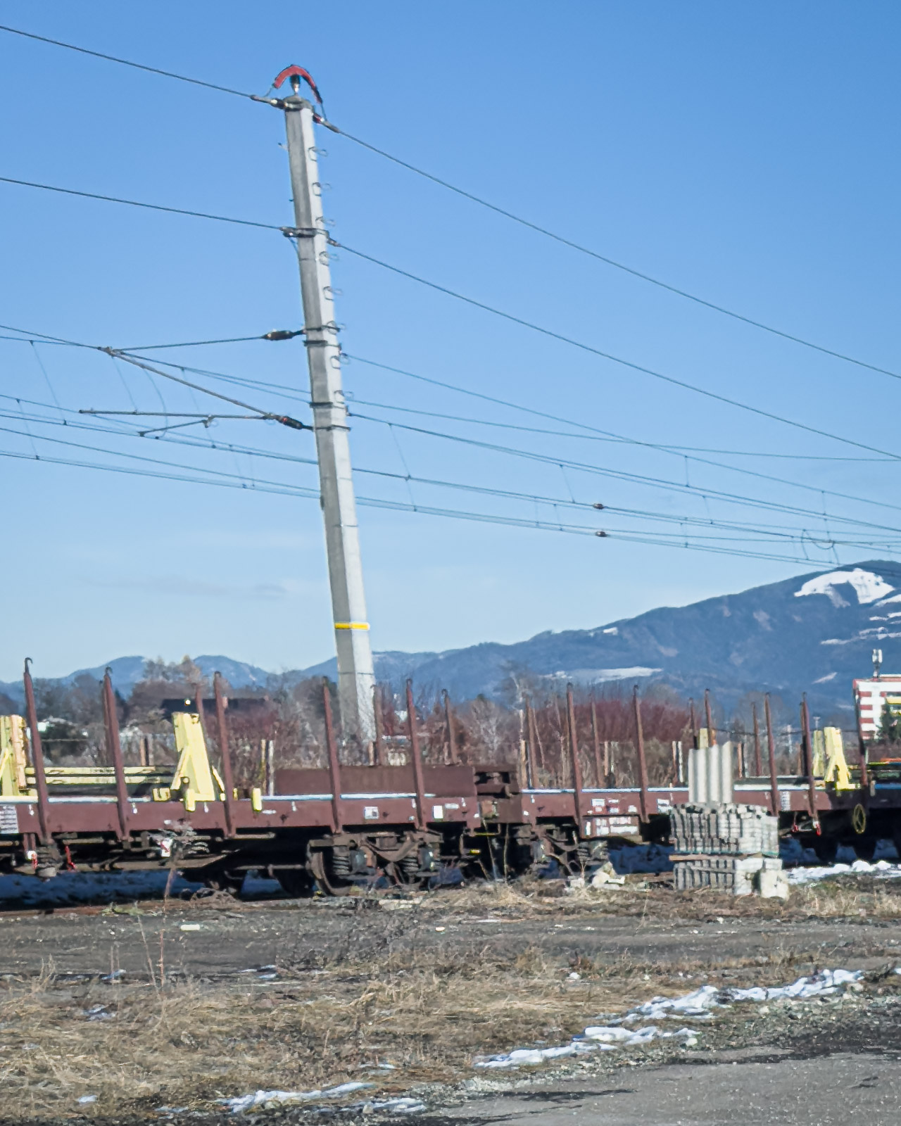 Railway infrastructure and power lines at an industrial yard in Zeltweg.