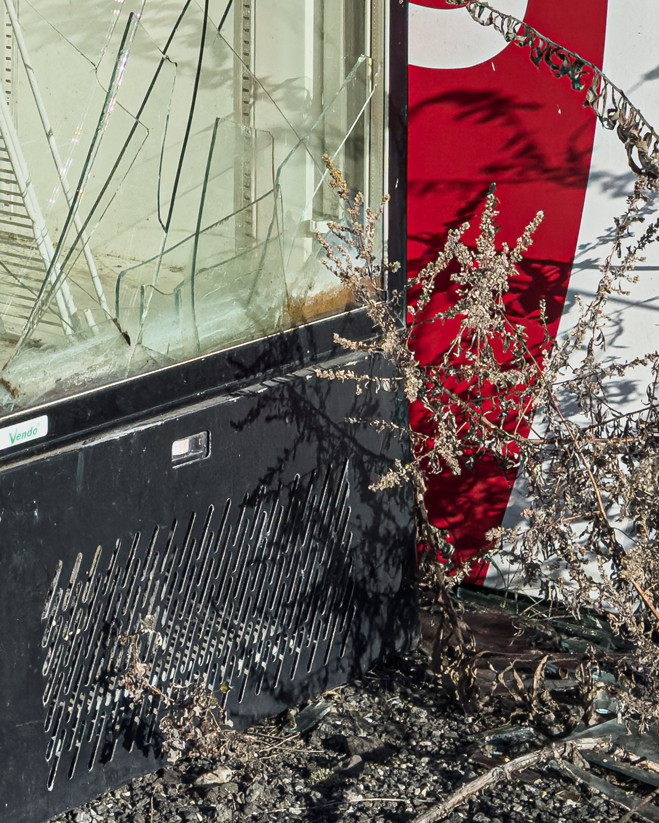 Broken glass and red Coca-Cola panel on an abandoned vending machine in Zeltweg